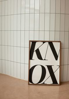 a black and white art piece sitting on top of a counter next to a tiled wall