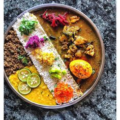 a metal plate topped with different types of food on top of a stone countertop