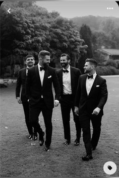 three men in tuxedos are walking through the grass together with trees in the background