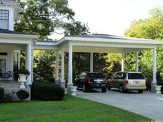 two cars are parked in front of a white house with pillars and columns on both sides