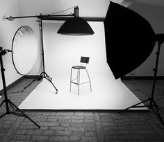 a black and white image of a chair in front of a photo studio with lights