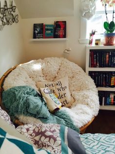 a bedroom with a chair and bookshelf full of books on the shelves next to it