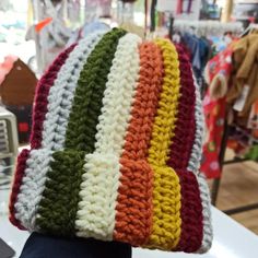 there is a multicolored crocheted hat on display