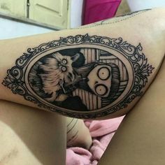 a woman's thigh with a black and white tattoo on it