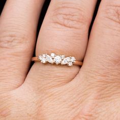 a woman's hand with an engagement ring on her left and three diamonds in the middle