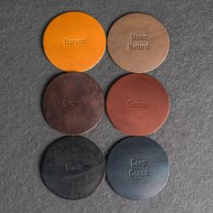 four metal coasters with names on them sitting next to each other in different colors