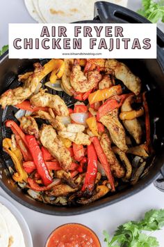 chicken fajita with peppers and onions in a skillet next to tortillas