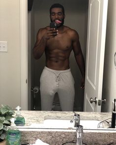 a shirtless man taking a selfie in the mirror