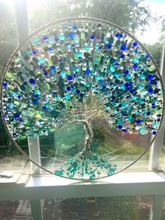 a glass tree is sitting on a window sill