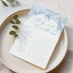 a table setting with place cards and greenery on the plate for guests to sign