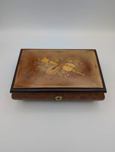 Vintage Reuge Wood Footed Music/Keepsake Box - Swiss musical movement - Made in Italy - Plays Taras Theme - Vintage musical instruments theme on top of lid - 8" wide x 5-1/4" Deep x 2-3/4" Tall - Pre-owned - some wear - Both sides of lid are quite worn/faded - plays well - no key Music Boxes Vintage, Vintage Musical Instruments, Music Box Vintage, Theme Vintage, Music Boxes, Box Signs, Keepsake Box, Music Box, Keepsake Boxes