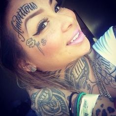 a woman with tattoos on her face and chest