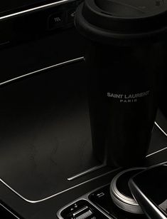 a black coffee cup sitting on top of a stove