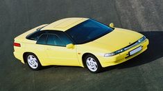 a yellow sports car is parked on the street