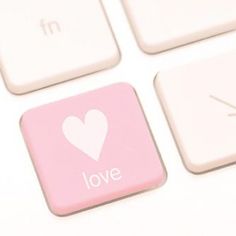 a close up of a keyboard with a pink love button on the left side and a white heart on the right side