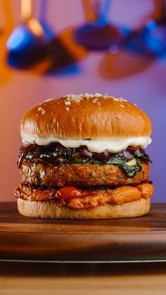 a burger with meat, cheese and sauce on a wooden plate in front of a purple background