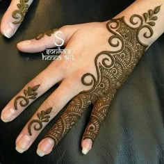 a woman's hand with henna tattoos on it