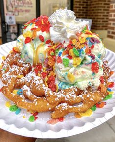 a white plate topped with waffles covered in ice cream and jelly bears surrounded by candy