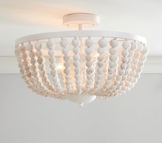 a white chandelier with beads hanging from it's center piece in a room