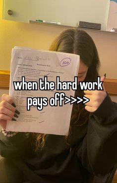 a woman holding up a piece of paper with the words when the hard work pays off