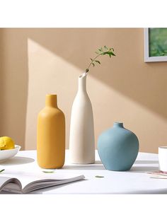 three vases sitting on top of a white table