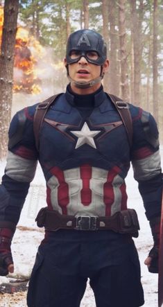 captain america is standing in the woods with his hands on his hips