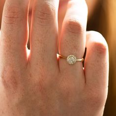 a woman's hand with a diamond ring on her finger, showing the center stone