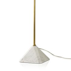 a white marble lamp with a gold metal base and a light bulb on the side