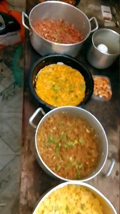 several pans filled with food sitting on top of a counter next to each other