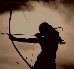 the silhouette of a woman holding a bow and arrow