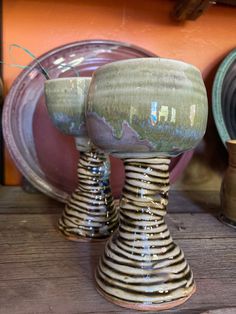 two ceramic vases sitting on top of a wooden table