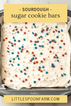 a cake with white frosting and sprinkles on it in a pan