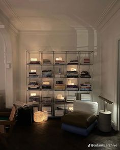 a living room filled with lots of furniture and bookshelves next to a window