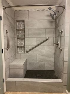 a walk in shower sitting inside of a bathroom next to a tiled floor and walls