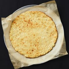 an uncooked tortilla sitting on top of a piece of wax paper