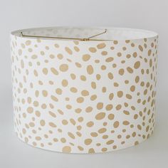 a white lamp shade with gold spots on it