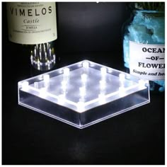 a bottle of wine sitting next to a glass with ice cubes in it on a table