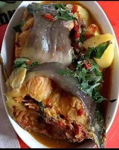 a white bowl filled with food on top of a red table cloth covered in silverware