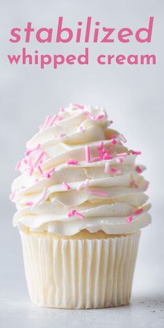 a cupcake with white frosting and pink sprinkles on the top