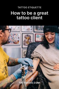 a woman getting her tattoo done by a man with blue hair and tattoos on his arm