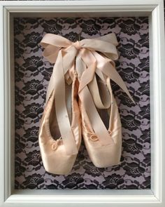 a pair of ballet shoes in a shadow box