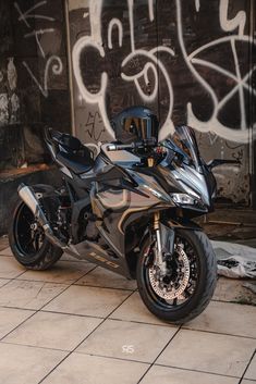 a motorcycle parked in front of a graffiti covered wall