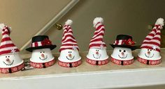 a group of snowmen wearing hats and scarfs on top of a shelf next to each other