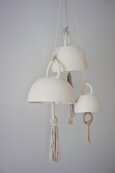 three white lamps hanging from ropes in a room