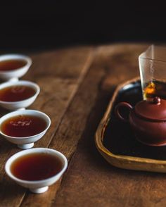 tea is being poured into small cups on a tray