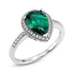 a green heart shaped ring with diamonds on the sides and an oval cut diamond in the middle