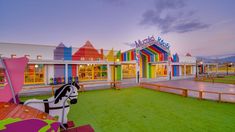 the colorful building has a horse statue on it's front lawn, and is painted in bright colors