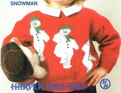 a young child wearing a snowman sweater holding a hat and mitten in their hands