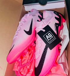 a pair of pink and black nike shoes in a box with the tag on it