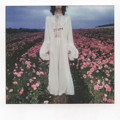 a woman standing in a field full of flowers